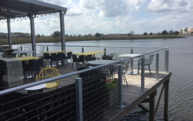 Laureate Park Restaraunt Dining Deck at Lake Nona Ipe Deck features stainless steel cable railing by Fender Marine Construction